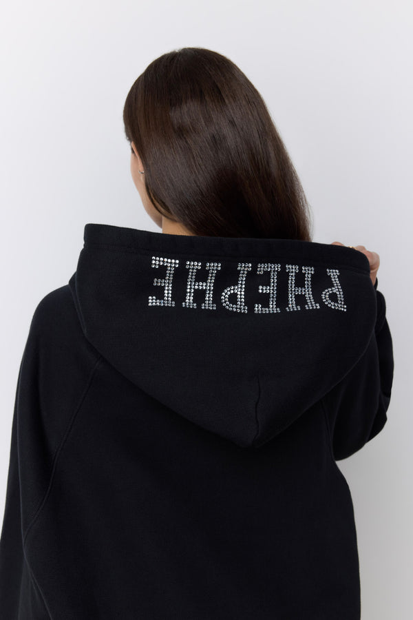 A person shown from behind wearing a black hoodie with the word 'PHEPHE' spelled out in sparkling silver rhinestones across the back of the hood, against a plain light gray background. |M1