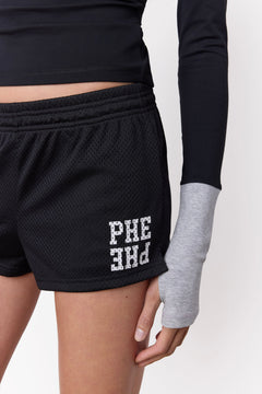 Black athletic mesh shorts with white 'PHE PHE' lettering on the lower left leg, shown on a model wearing a black long-sleeve top with grey cuffs and thumbhole sleeve against a plain white background.
